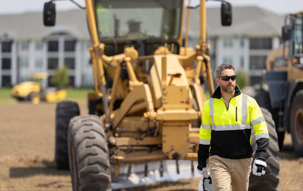 Lone Worker Walking Away From Construction Equipment