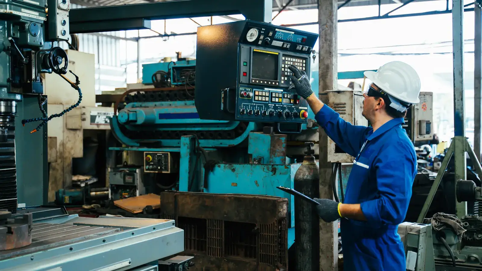 Operator working at an industrial machine control panel